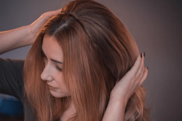 A Woman Fixing Her Hair Wig With Her Hands.